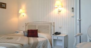 Cama ou camas em um quarto em Hôtel De France
