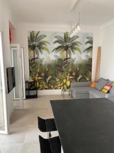 a living room with a painting of palm trees on the wall at LE CAMAS in Marseille