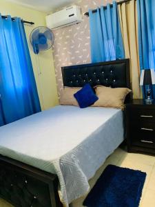 1 dormitorio con 1 cama grande y cortinas azules en Residencial monti 1, en Mendoza