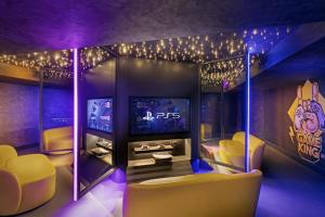 a room with a tv and yellow chairs and lights at Titanic Deluxe Lara in Lara