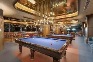 a billiard room with two pool tables and chandeliers at Titanic Deluxe Lara in Lara