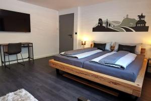 1 dormitorio con 1 cama grande y TV de pantalla plana en Mosel19 - Moderne, hochwertige Ferienwohnung en Niederfell