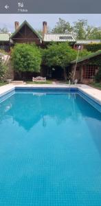 una gran piscina azul frente a una casa en PARAISO en Mendoza