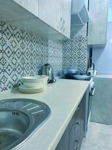 a kitchen with a counter with a sink in it at Студия в ЖК Ушсункар in Almaty