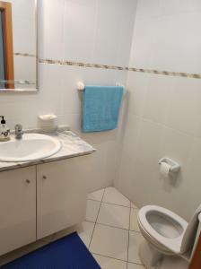 a white bathroom with a toilet and a sink at Mar & Morna in Mindelo