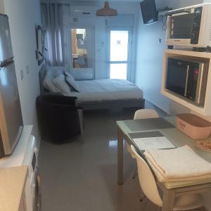a small room with a bed and a table with a laptop at studio by the sea in Ashdod +14 photos
