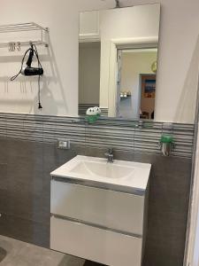 een badkamer met een witte wastafel en een spiegel bij PortaMedina House in Napels