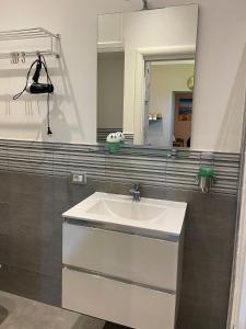 un bagno con un lavandino bianco e uno specchio di PortaMedina House a Napoli Altre 37 foto