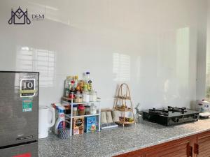 a kitchen with a counter top with a refrigerator at DeMi Homestay - Châu Đốc in áº¤p VÄ©nh ÃÃ´ng