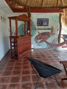um quarto com uma rede de descanso e uma parede com um mural em Andivi em Arroyo Cruz