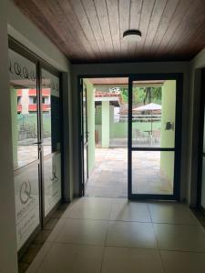 an empty hallway with glass doors in a building at Barra Apart Service in Salvador