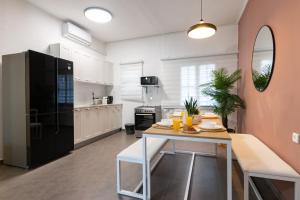 eine Küche mit einem Tisch und einem schwarzen Kühlschrank in der Unterkunft O&O Group - Stunning Chic 2 BR Ibn Gvirol St in Tel Aviv