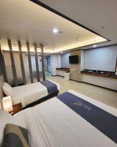 a hotel room with two beds and a projection screen at Hotel Gongjicheon in Chuncheon