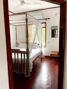 1 dormitorio con 1 cama con dosel en Wasana Villa Mirissa, en Mirissa