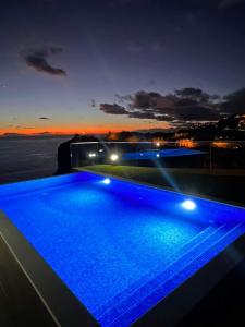 a swimming pool with blue lights on top of a building at Madeira Sea Sunshine with heated pool in Ribeira Brava