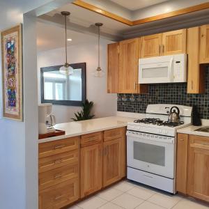 a kitchen with wooden cabinets and a white stove top oven at Ocean Breeze Villa 242 in Nassau