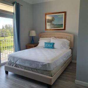 a bed with a blue pillow on it in a bedroom at Ocean Breeze Villa 242 in Nassau +24 photos