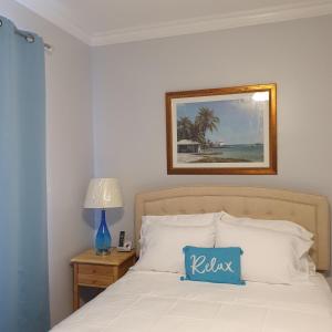 um quarto com uma cama com uma almofada azul em Ocean Breeze Villa 242 em Nassau