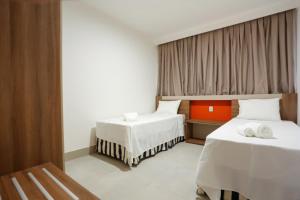 una camera d'albergo con due letti e una finestra di Enjoy Resort em frente Thermas até 5 pessoas a Olímpia Altre 16 foto