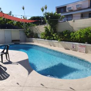 a small swimming pool with a chair next to a building at Ocean Breeze Villa 242 in Nassau