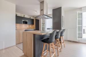 a kitchen with a island with bar stools at Sunny Lake by Plaza - Proche Disneyland Paris in Serris