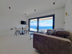 a living room with a couch and a large window at The Five Stars Croatia in Novi Vinodolski