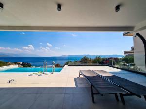 a house with a view of a swimming pool and a bench at The Five Stars Croatia in Novi Vinodolski