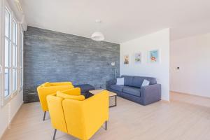 a living room with yellow chairs and a couch at Sunny Lake by Plaza - Proche Disneyland Paris in Serris