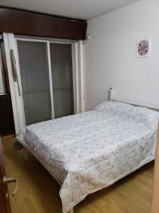 1 dormitorio con 1 cama con edredón blanco en Departamento ubicadisimo calle Chile con estacionamiento incluido capital Mendoza 4 en Mendoza