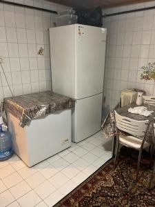 a kitchen with a refrigerator and a table and a chair at Daire in Istanbul