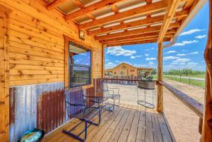 a log cabin deck with chairs and a large window at Moon View in Fredericksburg