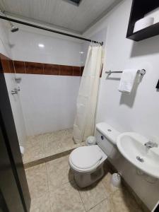 Baño blanco con aseo y lavamanos en Casa Horeb, en Salento