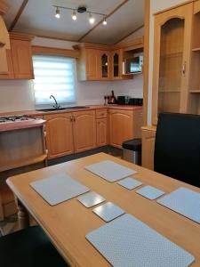 a kitchen with a wooden table with mats on it at Cornwall CORNWALL-CHAPMANSWELL CARAVAN HOLIDAY PARK A30 B&B Bed and breakfast #41 in Launceston