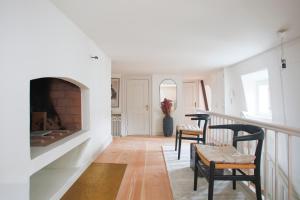 a living room with a fireplace and two chairs at Modern 3BR Duplex Flat in Nyhavn w Private Balcony in Copenhagen