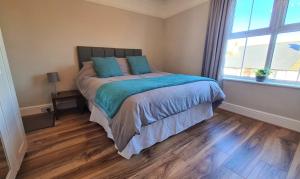 Un dormitorio con una cama con almohadas azules y una ventana en Castle Cottage en Rayleigh