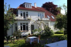 une maison blanche avec une table et des chaises dans la cour dans l'établissement villa apartment with sea view, à Copenhague