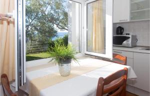 una cocina con mesa y una ventana con una planta. en Awesome Apartment In Mimice With Wifi en Mimice