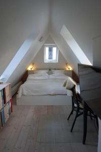 a bedroom with a white bed in a attic at villa apartment with sea view in Copenhagen