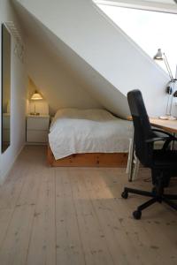 a bedroom with a bed and a desk and a chair at villa apartment with sea view in Copenhagen +24 photos