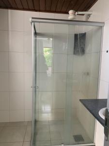 a glass shower in a bathroom next to a sink at Barra Apart Service in Salvador