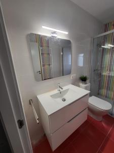 a bathroom with a sink and a toilet and a mirror at Casa albalunasss in Salamanca