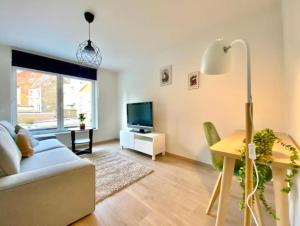 ein Wohnzimmer mit einem Sofa, einem Tisch und einem TV in der Unterkunft City and Nature in Gent