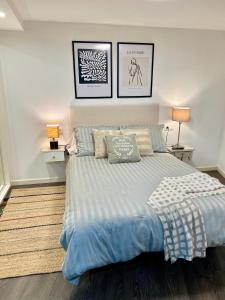 a bedroom with a large bed with two pictures on the wall at El patio de Lindo in Córdoba