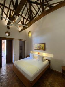 ein Schlafzimmer mit einem Bett in einem Zimmer mit Holzdecken in der Unterkunft Misia Custodia Hotel Boutique in Barichara