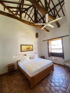 sypialnia z dużym łóżkiem w pokoju z drewnianym sufitem w obiekcie Misia Custodia Hotel Boutique w mieście Barichara