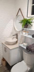 a white bathroom with a sink and a toilet at Dorvic Cottage in Bridgetown