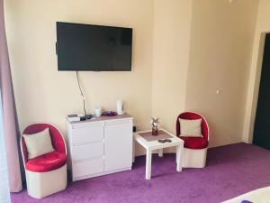 Dworek Ewunia في فيسلا: غرفة بها كرسيين ومكتب وتلفزيون