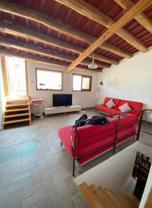 sala de estar con cama roja y sofá en apartamento cerca de tren, playa y Barcelona, en Masnou