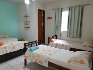 pokój z 3 łóżkami i oknem w obiekcie Aquarela Suítes w mieście Piúma