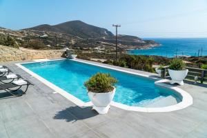 a swimming pool with a view of the ocean at Villa Tani in Agios Georgios